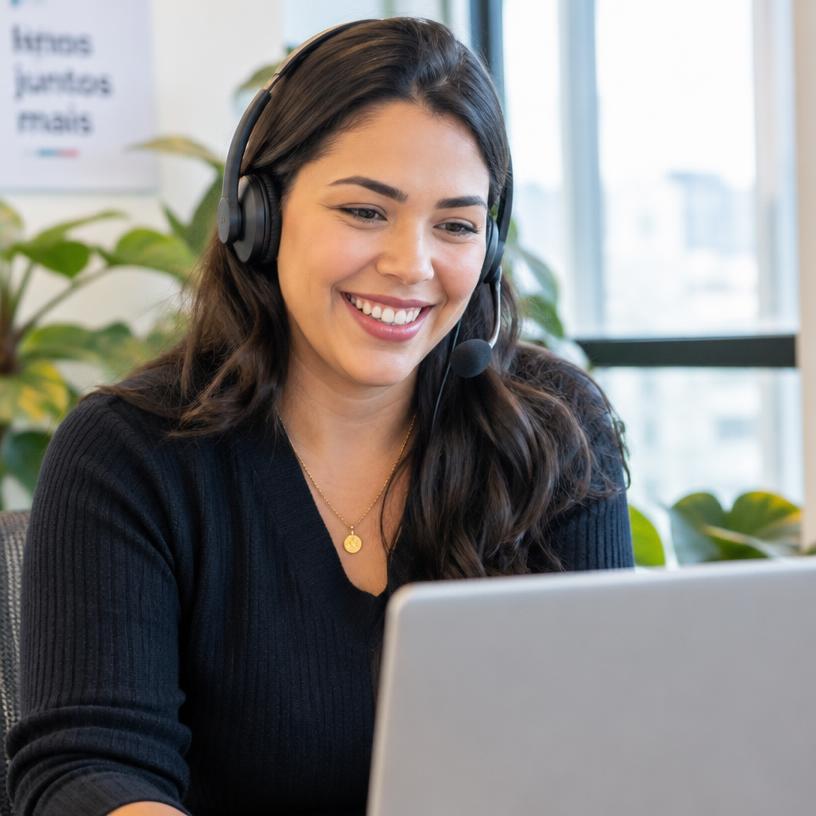 Especialista da equipe Estuda sorrindo durante um atendimento